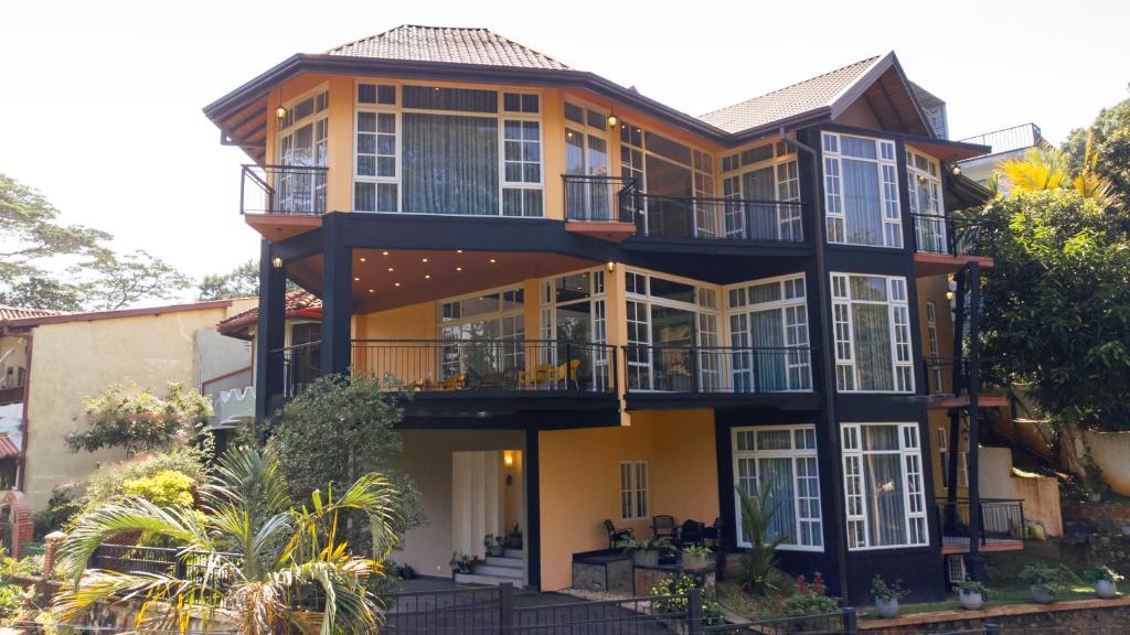 康提Roberosia - Holiday Home的带阳台和树木的大型黄色房屋