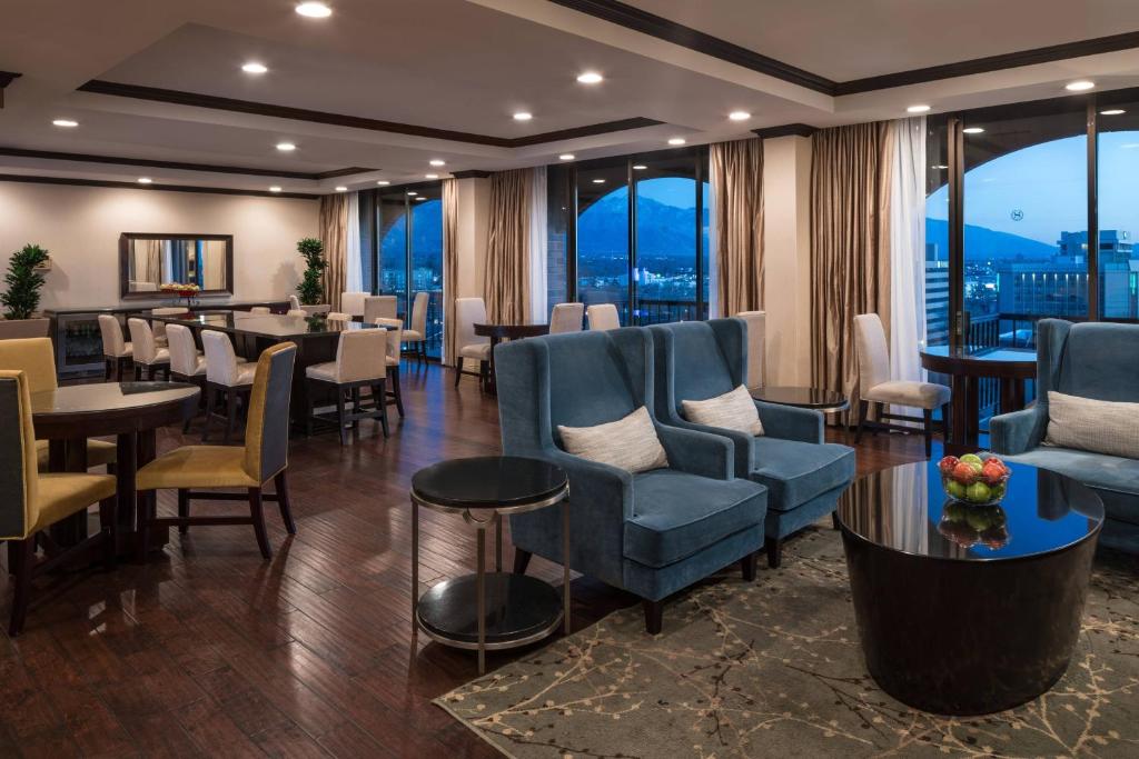 盐湖城盐湖城喜来登酒店的餐厅设有蓝色的椅子和桌子以及窗户。