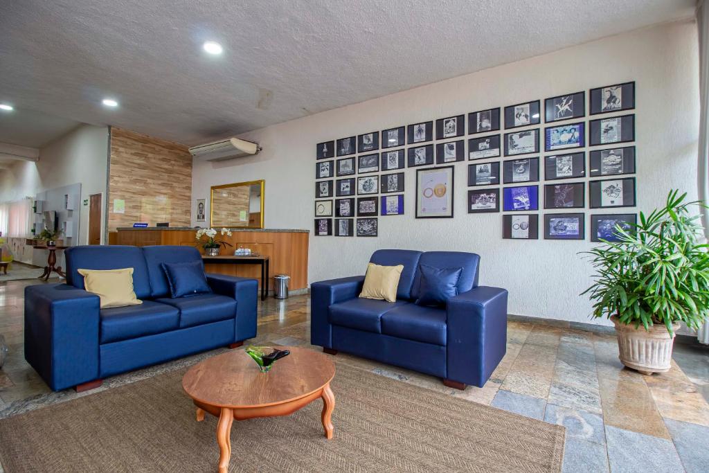巴雷图斯Hotel Dan Inn Barretos的客厅配有2张蓝色的沙发和1张桌子