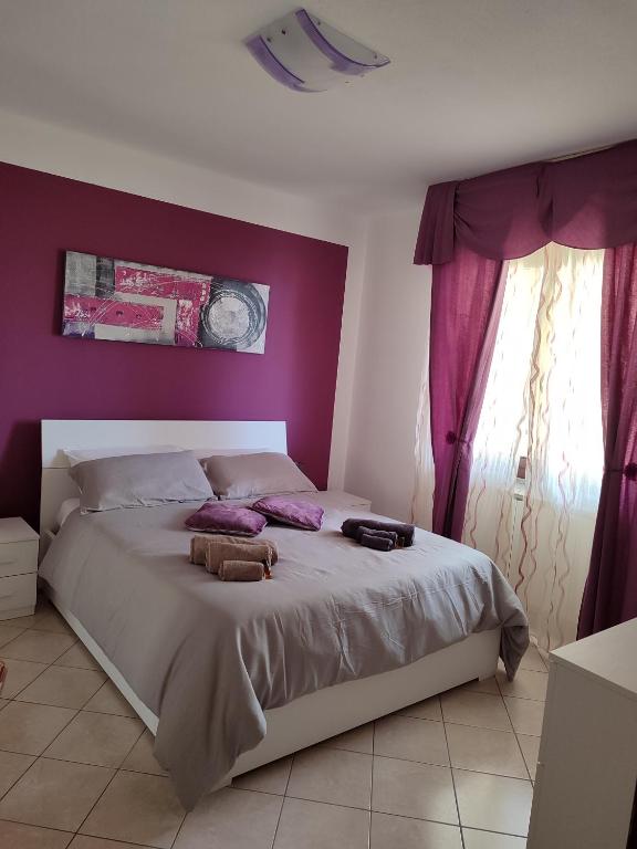 萨萨里Dario's house的一间卧室设有一张紫色墙壁的大床