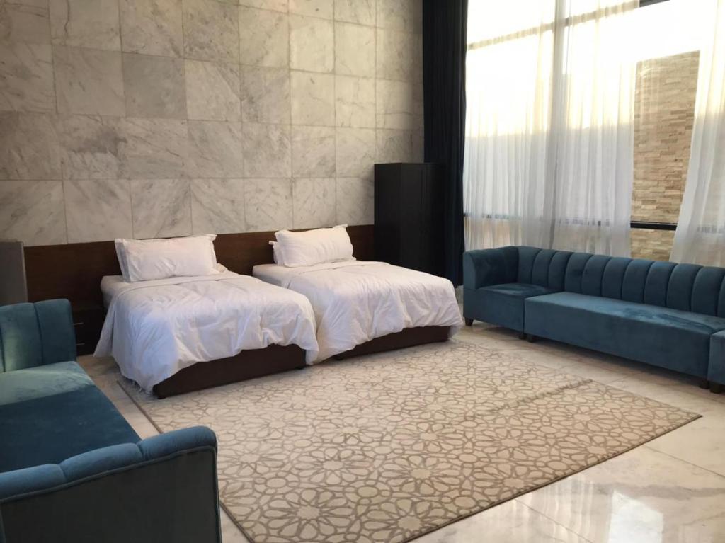 Al GhuţghuţSAAF RESORT的一间卧室配有一张床和一张蓝色的沙发