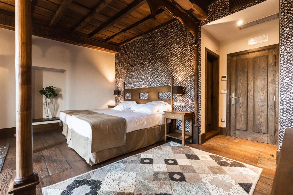 曼萨内达曼萨内达佩纳宫乡村民宿的一间卧室设有一张大床和木墙