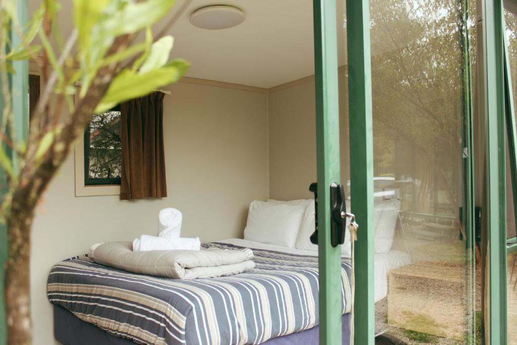 玛拉豪The Barn Cabins & Camp的一间卧室设有一张床和一个滑动玻璃门