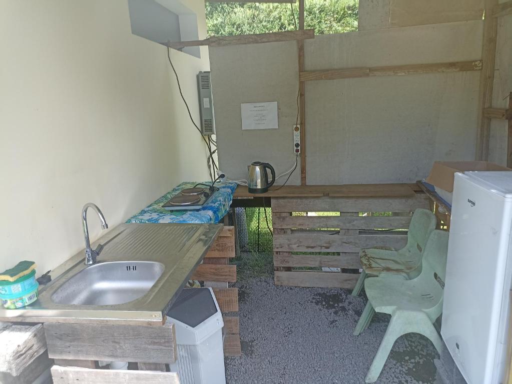 TaputapuapeaCamping TENUI的一个带水槽和书桌的小厨房