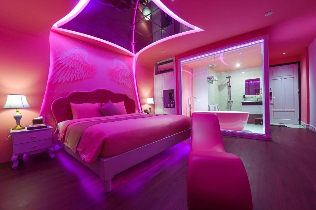 岘港Chiic House 2 - Khách sạn tình yêu的粉红色的卧室设有一张大床和一个浴缸