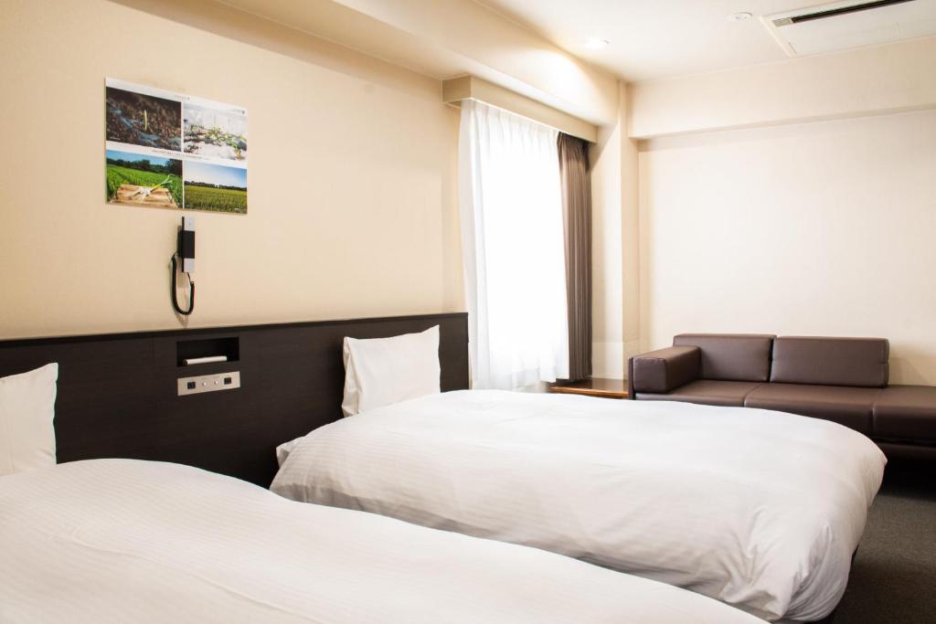 府中市大陆府中酒店的酒店客房,设有两张床和一张沙发