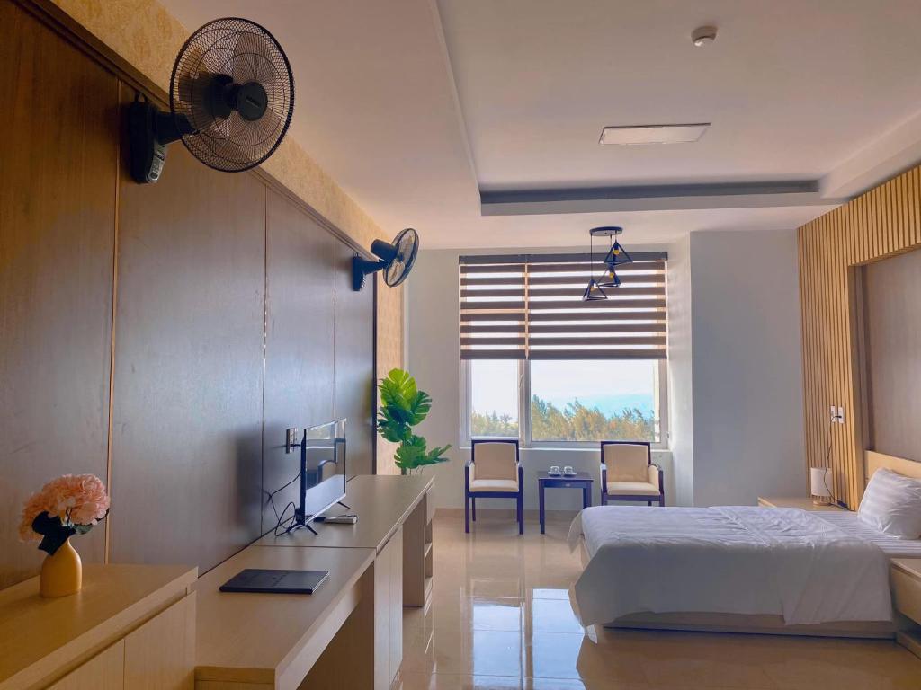 洞海Khách sạn 20-10 Quảng Bình的一间卧室配有一张床和一张带风扇的书桌