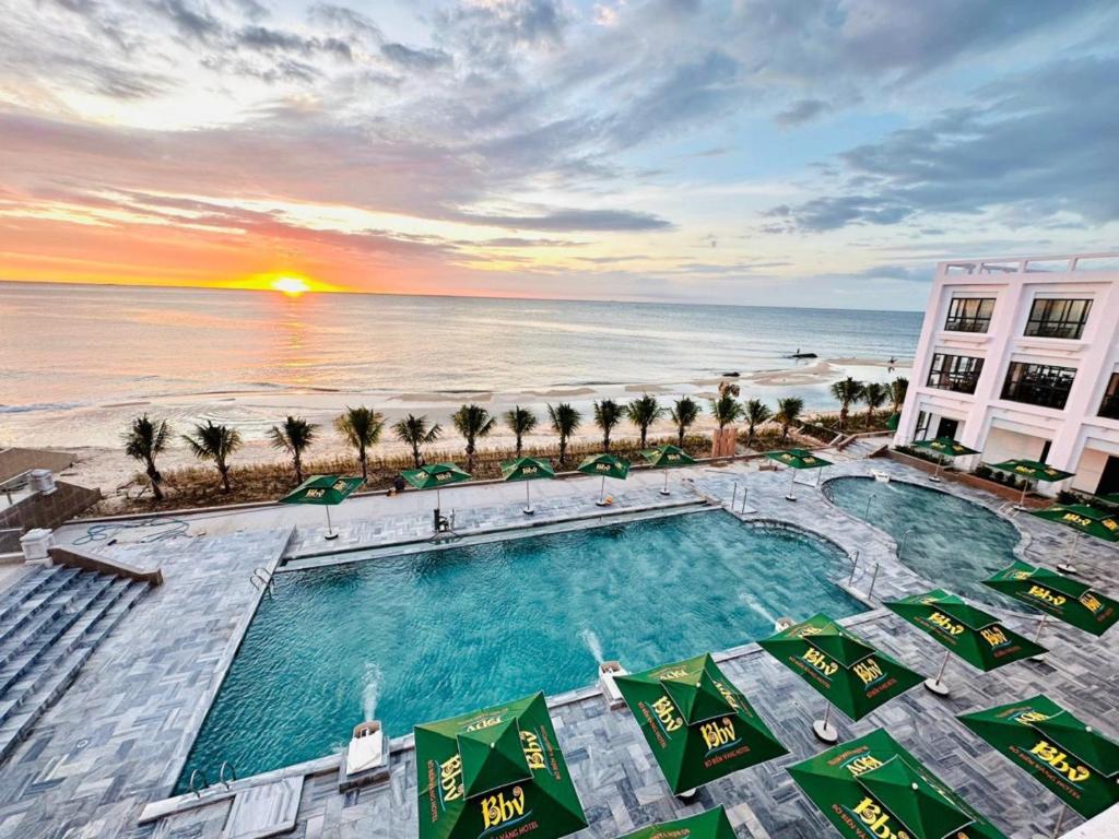 嘎那角Bờ Biển Vàng Hotel的日落时分享有游泳池和海滩的顶部景致
