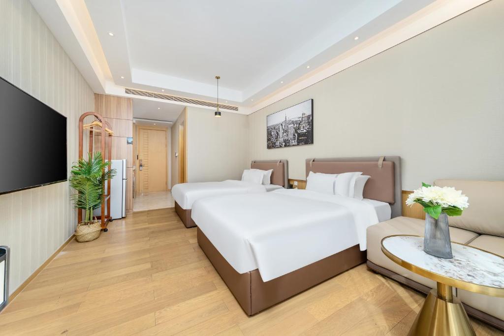 广州東枫国际公寓(广州国际金融城科韵路地铁站店)的一间酒店客房,设有两张床和电视