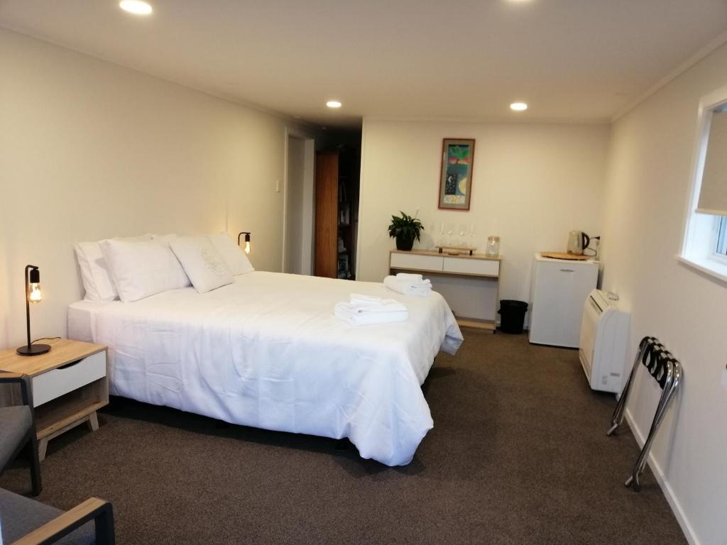 纳尔逊Reeves Retreat-Handy in Tasman的卧室配有一张白色大床和一张书桌