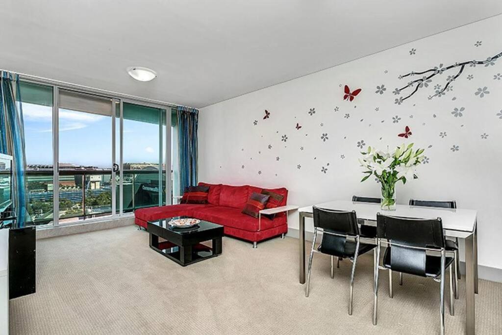 悉尼SX339 - CBD Chinese Gardens Views, Modern 2BR Apt的客厅配有红色的沙发和桌子