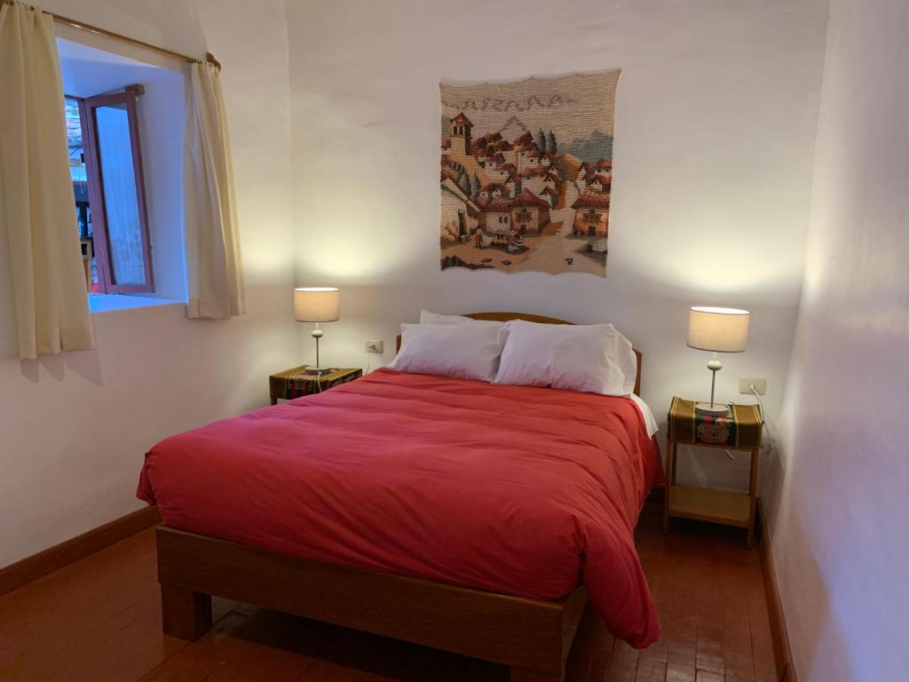 库斯科Hospedaje Killipata的一间卧室配有一张红色大床和两盏灯