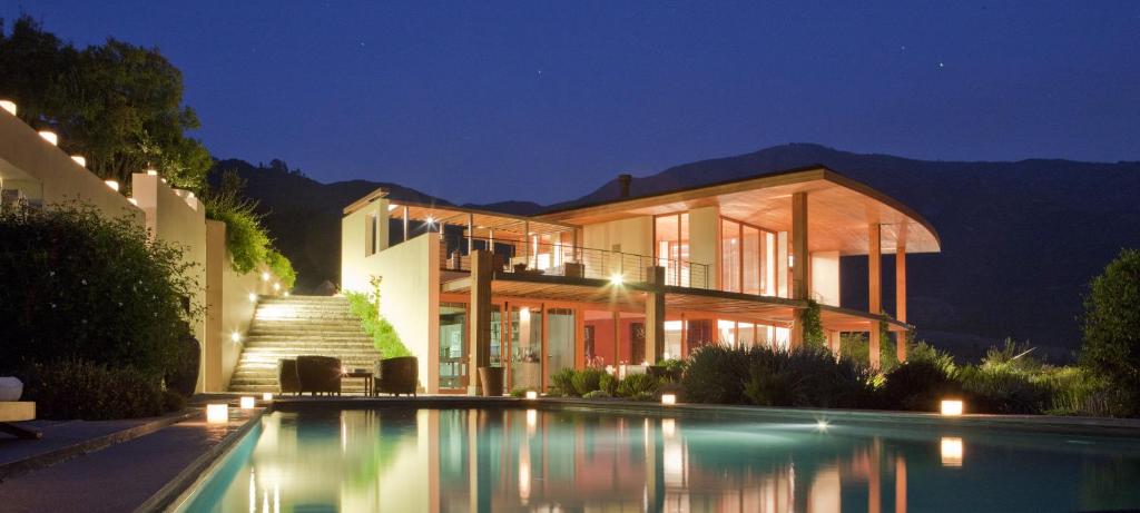 圣克鲁兹Clos Apalta Residence Relais & Chateaux的一座晚上设有游泳池的房子