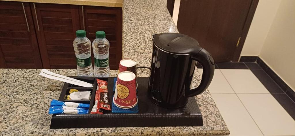 阿尔卡吉ريف الخرج 2 للشقق الفندقية的咖啡壶和柜台上的两瓶水