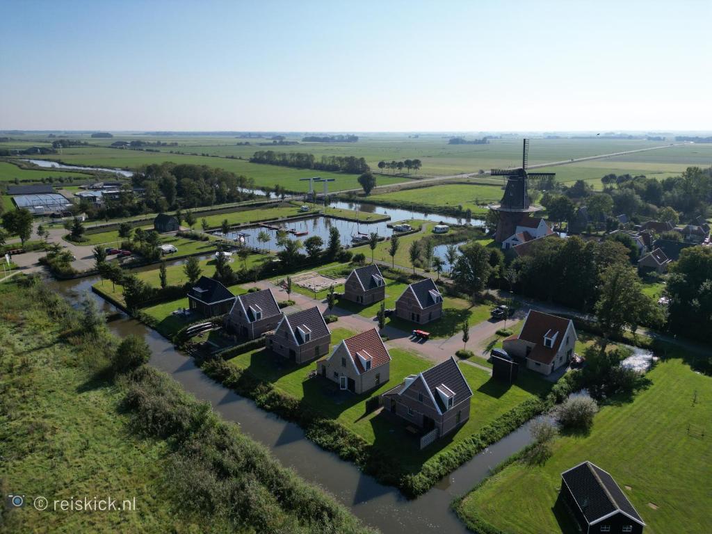 BirdaardWaterdorp Burdaard的享有村庄的空中景致,设有房屋和河流