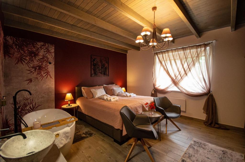 久洛Boutique Villa Gyula的一间卧室配有一张床、一个浴缸和一个水槽
