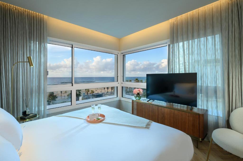 特拉维夫Jewel TLV Hotel的卧室设有一张白色大床和大窗户