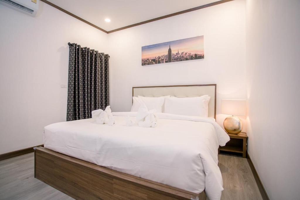 清迈De Thaphae Chiangmai的卧室设有一张白色大床和一扇窗户。