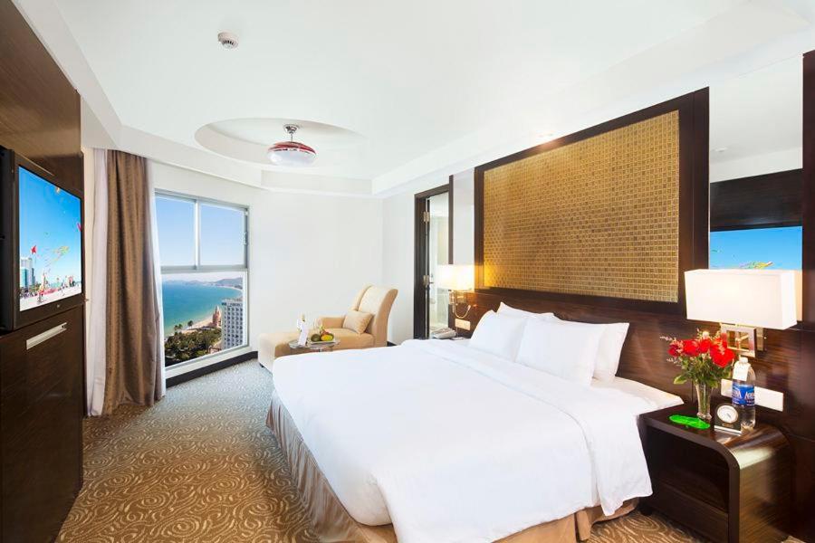 芽庄芽庄哈瓦那酒店的卧室设有一张白色大床和大窗户