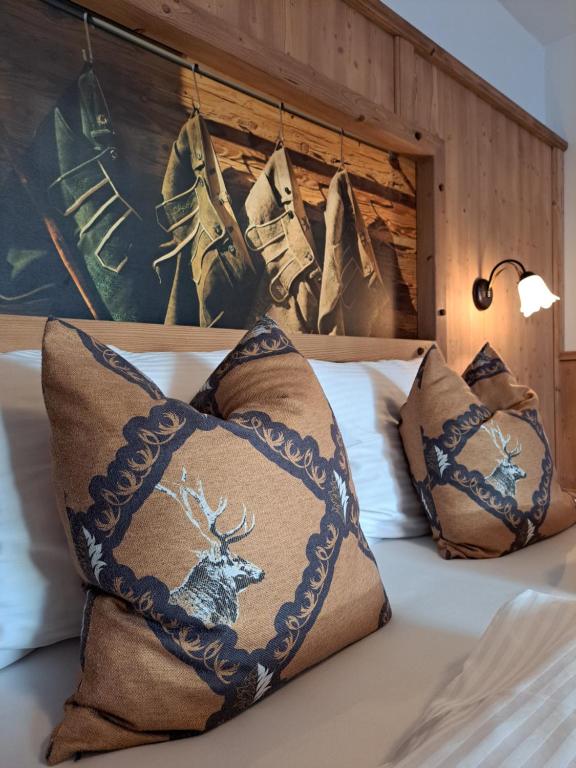 因斯布鲁克Gasthof Stauder的床上配有枕头,上面有鹿