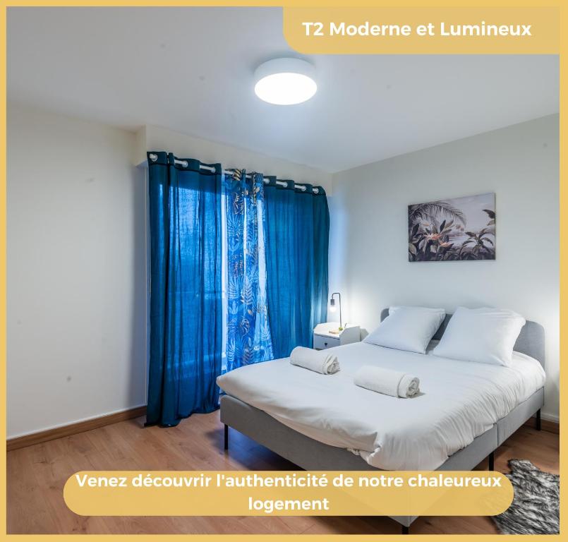 盖拉德Appartement T2 Moderne Gaillard的一间卧室配有一张带蓝色窗帘的大床