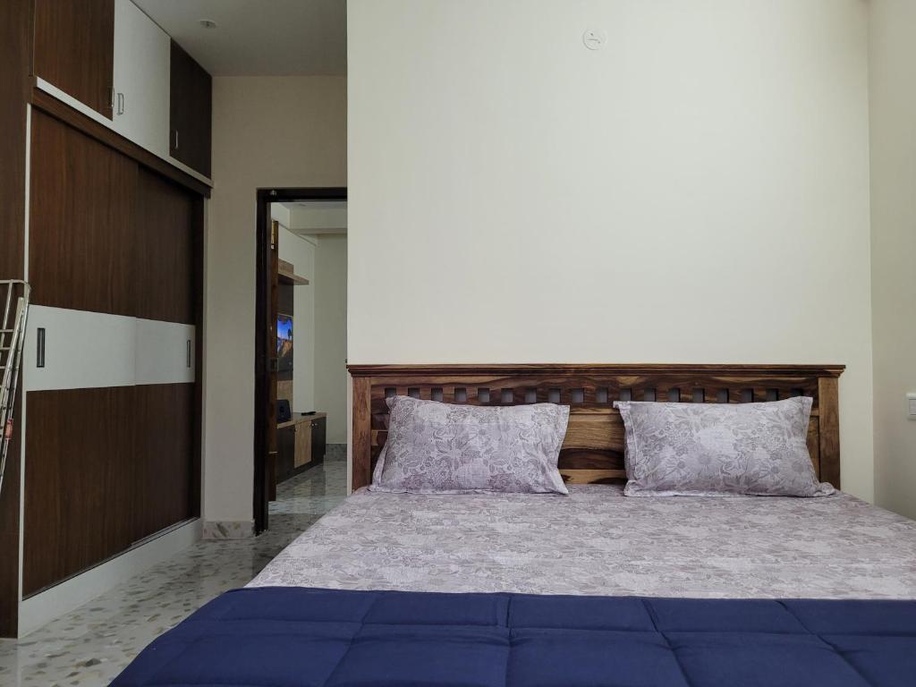 班加罗尔Castle Hebbal Service Apartments的一间卧室配有一张大蓝色的床和两个枕头