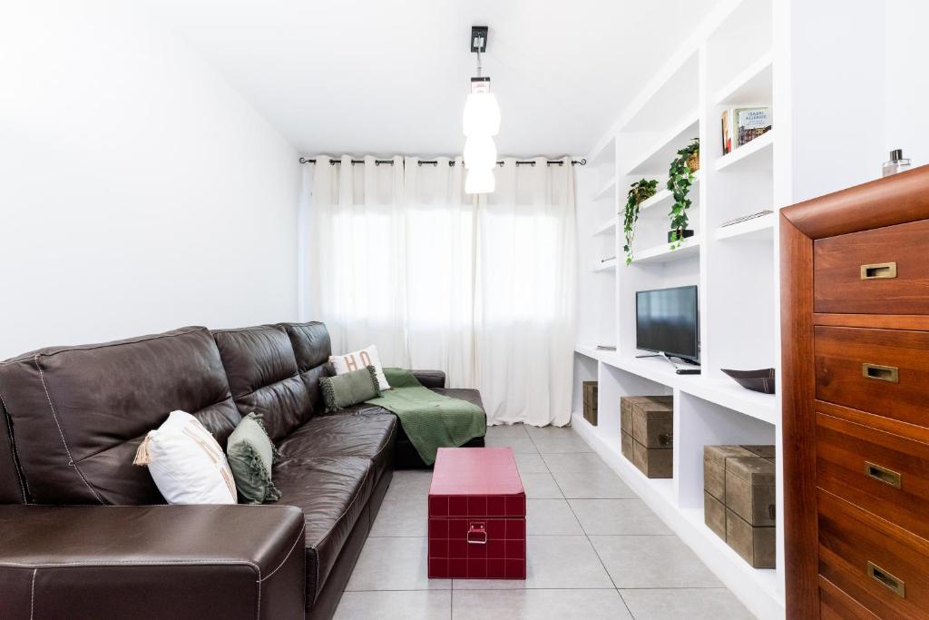 格拉纳达tuGuest Avenida de la Investigación的客厅配有棕色真皮沙发和电视
