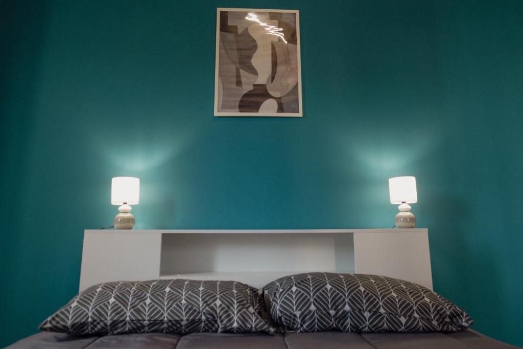 伊格莱西亚斯Casa Vacanze - Il Balconcino sul Castello的一间卧室设有绿色的墙壁和一张带两盏灯的床。