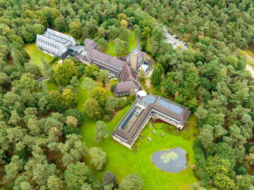 宰斯特Hotel Woudschoten的森林中央建筑物的空中景观