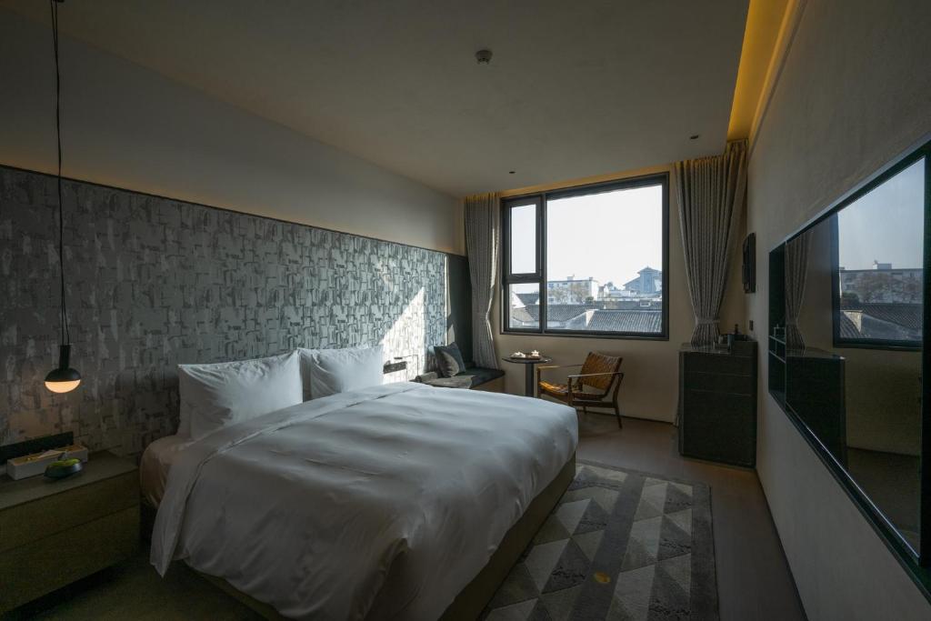 苏州苏州观前街有熊酒店的卧室设有一张白色大床和一扇窗户。