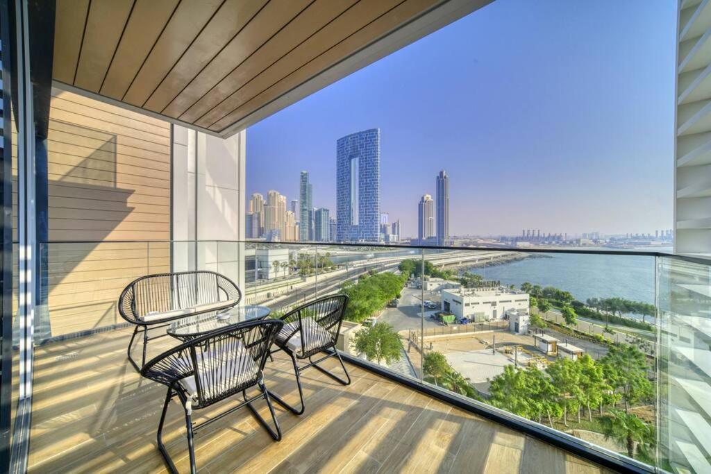 迪拜Livbnb - Elegant 3BR+Maid, Sea View in Bluewaters的市景阳台配有1张桌子和2把椅子。