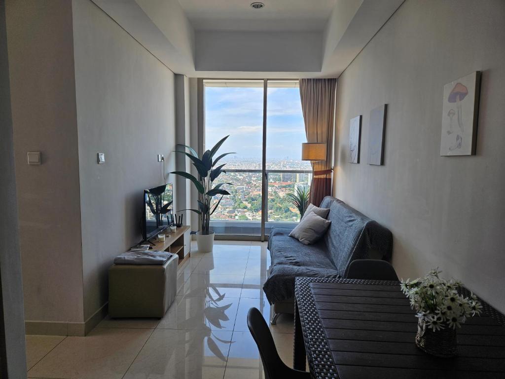 雅加达3BR Flat in Taman Anggrek Residence的带沙发和大窗户的客厅