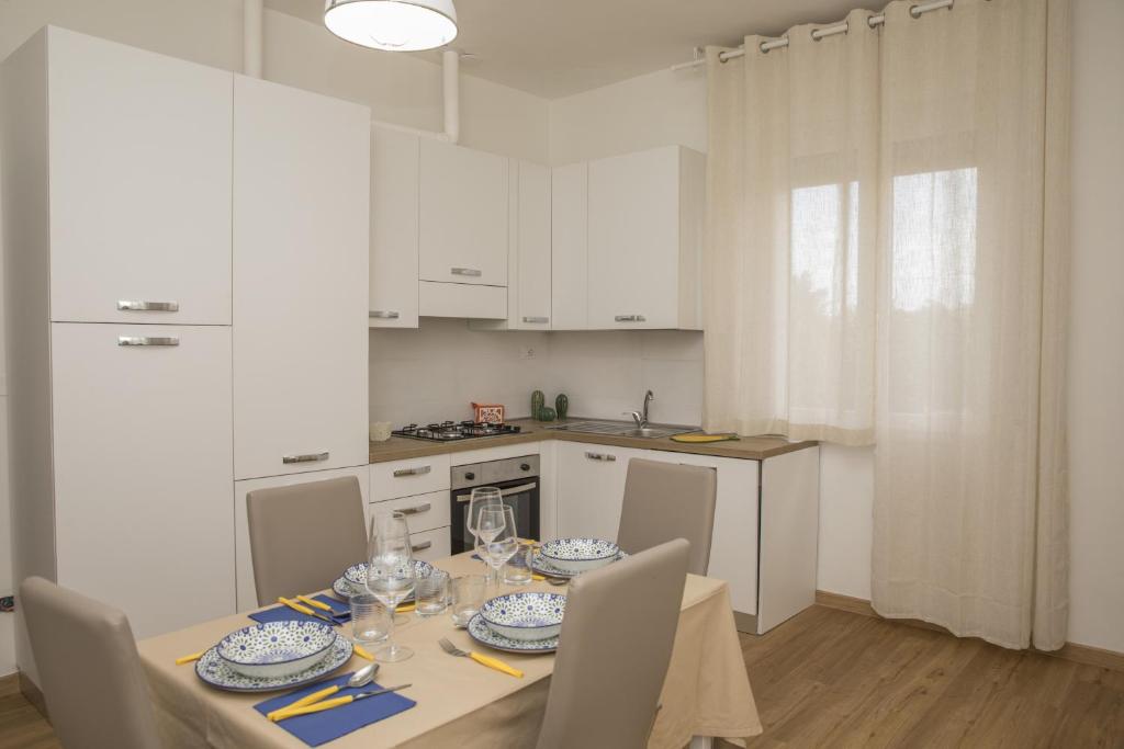 卡斯泰莱门多La Casa dei Racconti的白色的厨房配有桌椅