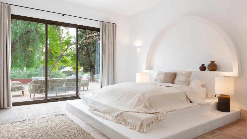 科因Finca La Familia Naranja的白色的卧室设有一张大床和一个大窗户