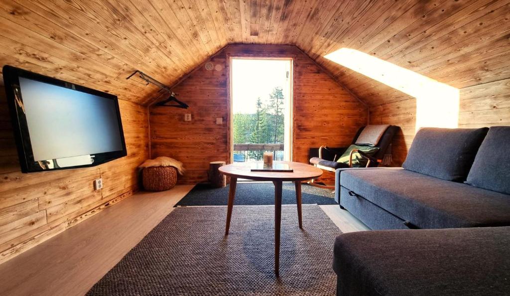 基律纳Cozy Cabin Styled Loft的客厅配有沙发和墙上的电视