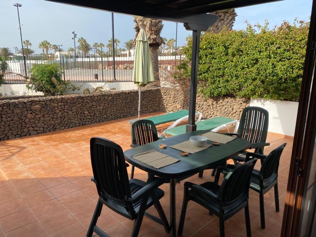 普拉亚布兰卡Las Brisas, Villa 98的庭院里配有桌椅和遮阳伞