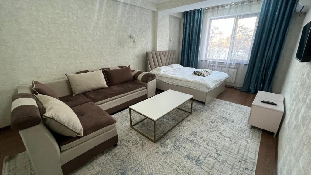 比什凯克Apartament Manasa的客厅配有沙发和桌子