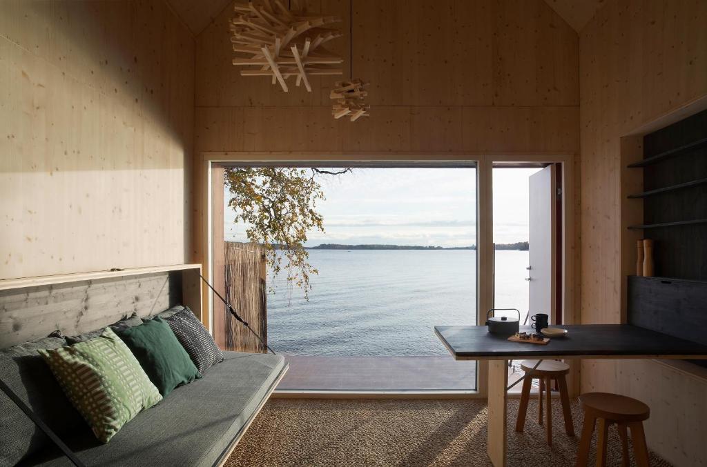 赫尔辛基Majamaja Helsinki off-grid retreat的带沙发的客厅,享有水景