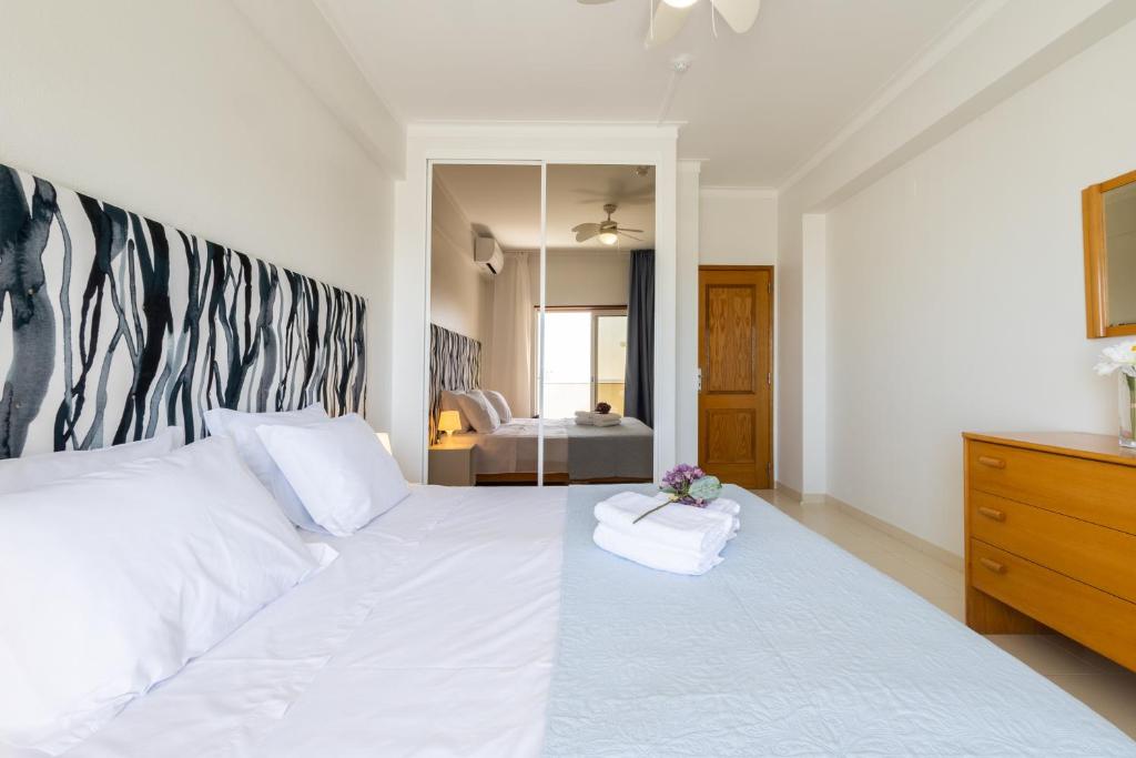 珀彻斯Casa Azul 3 - Senhora da Rocha, Algarve的卧室配有一张带镜子的白色大床
