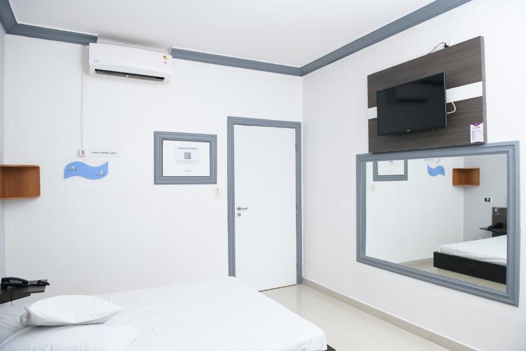 博阿维斯塔Nidore Motel的一间卧室配有一张床,墙上配有电视