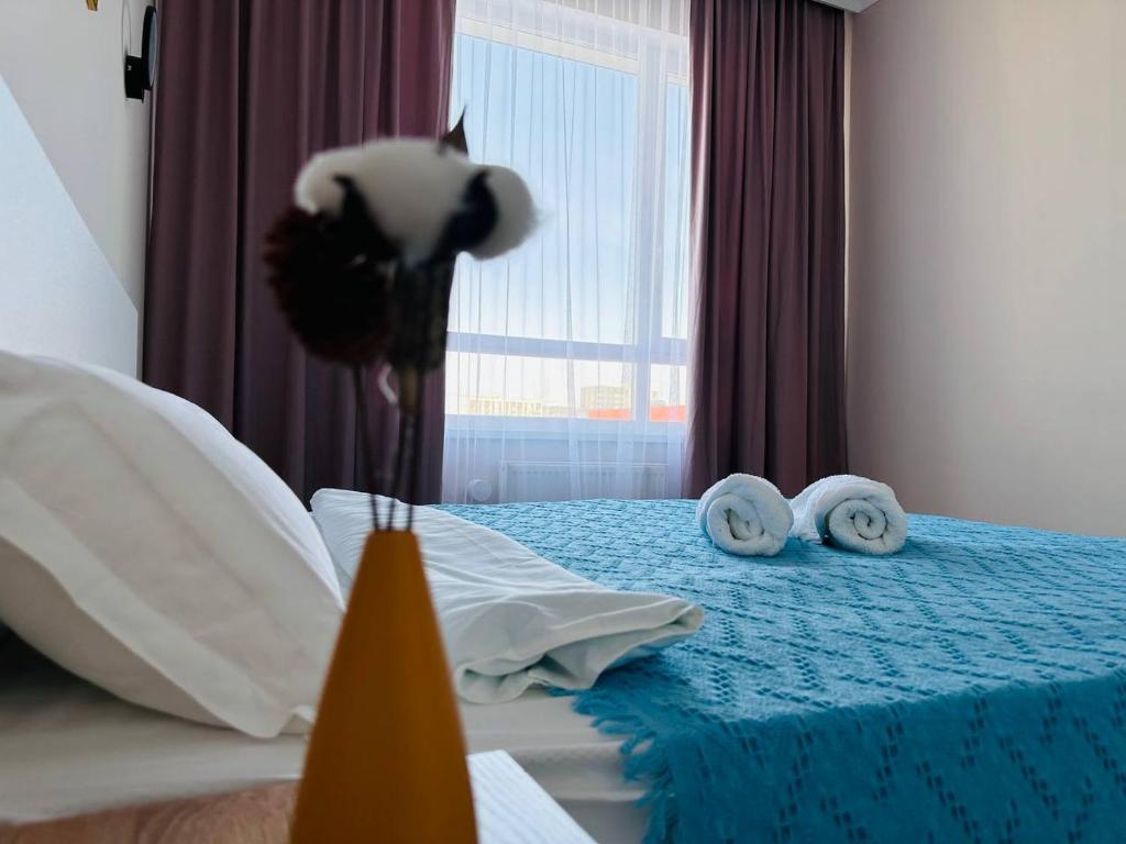 塔尔迪科尔Уютный уголок в центре города Grand Turan的一间卧室配有蓝色的床和毛巾
