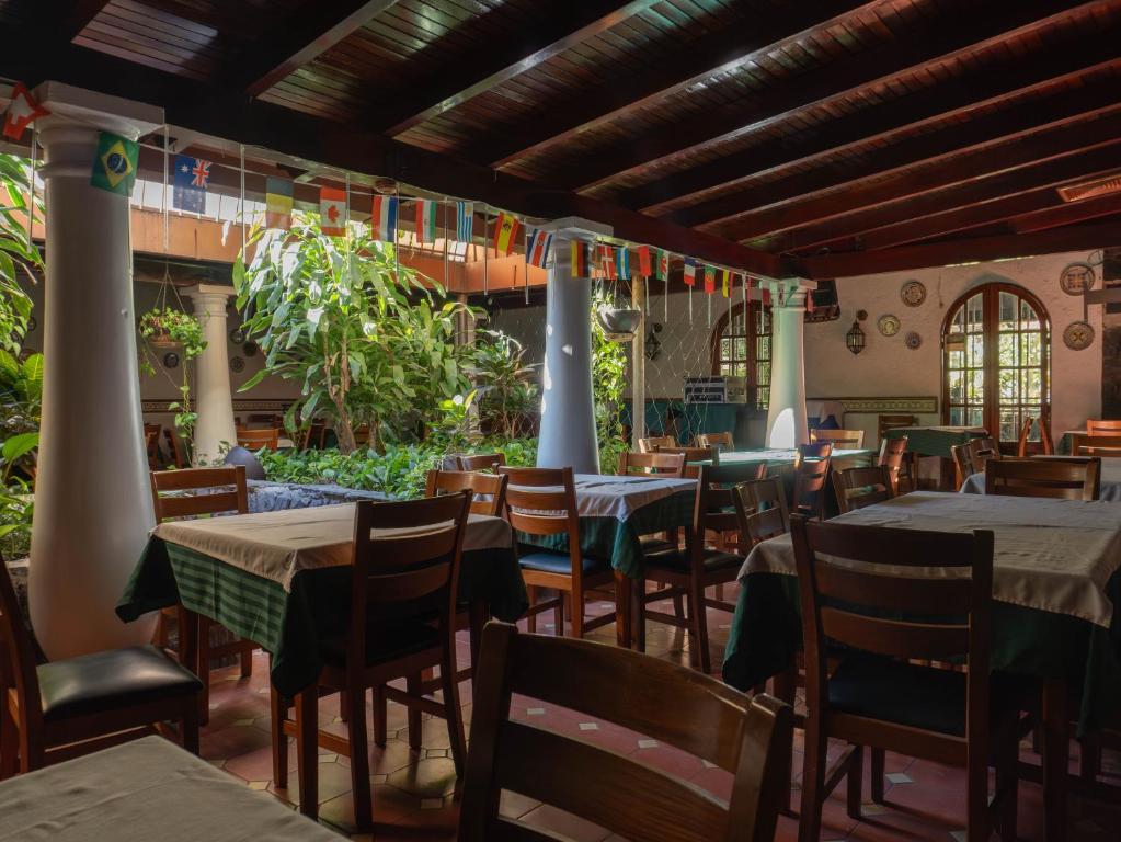 加拉加斯Hotel El Arroyo的一间在房间内配有桌椅的餐厅