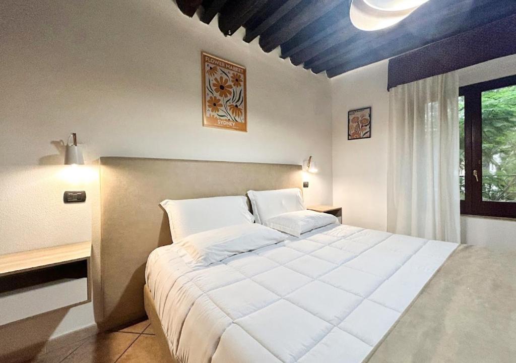 卡利亚里撒丁尼亚多莫斯酒店的卧室设有一张白色大床和一扇窗户。