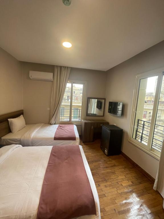 开罗New Lotus Hotel的酒店客房设有两张床和电视。