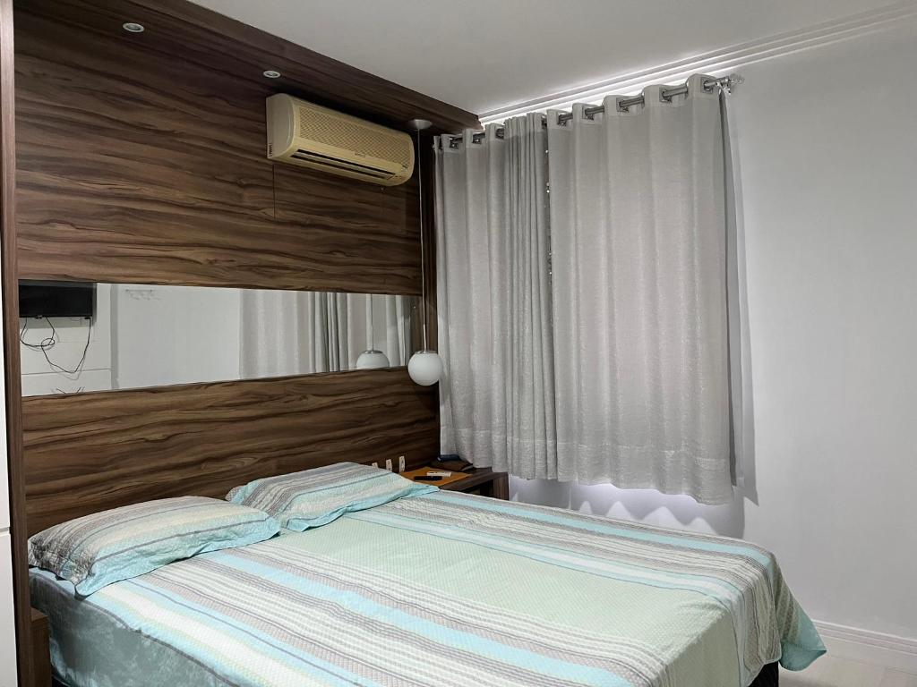 布卢梅瑙Suítes e quartos no Centro de Blumenau的一间卧室设有一张床和一个窗口