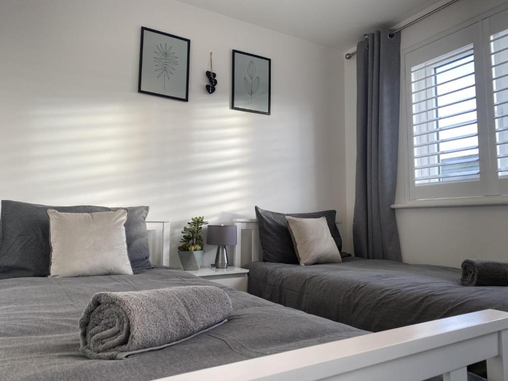 伯特利Modern Home Birtley的一间卧室设有两张床和窗户。