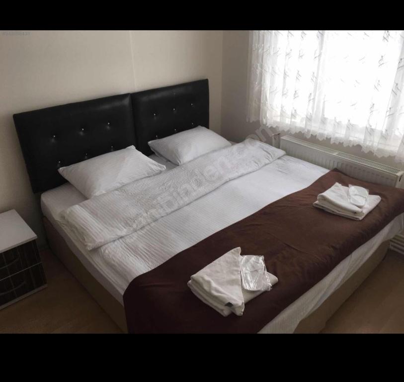 SulusarayWHİTE SUİT的一张大床,上面有两条毛巾