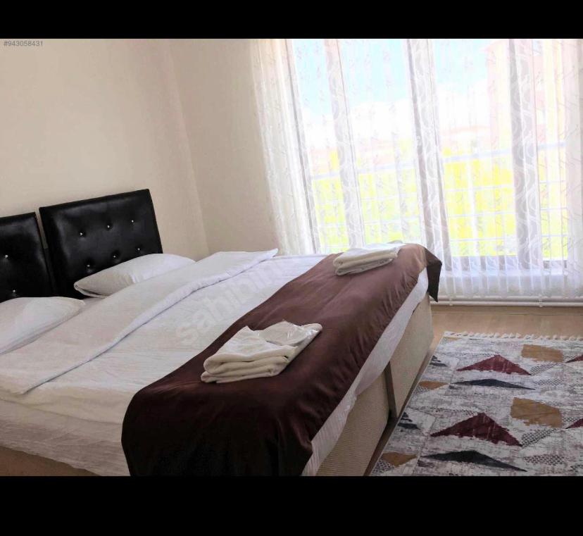 SulusarayWHİTE SUİT的一间卧室配有一张床,上面有两条毛巾