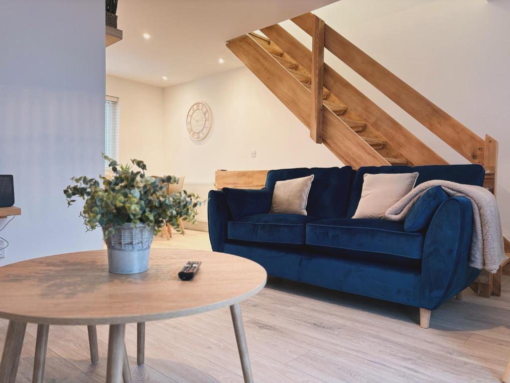 米勒姆23 Coastal Comfort的客厅配有蓝色的沙发和桌子