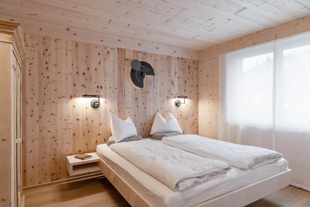 Ferienwohnung Waldzauber Erleben的卧室设有白色大床和木墙